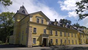 een groot geel gebouw met een toren bij Pałac Lucja BB in Zakrzów