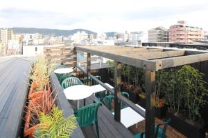 d'un balcon sur le toit avec des tables et des chaises. dans l'établissement Kyomachiya Ryokan Sakura Urushitei, à Kyoto