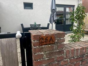 Una pared de ladrillo con un cartel. en T-Rots, prachtig zomerhuis en Noordwijk aan Zee