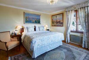 a bedroom with a bed and a chair and a window at Golden Well in Prague