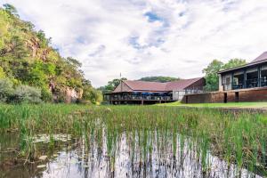 a resort with a pond in front of it at ATKV Klein-Kariba in Bela-Bela