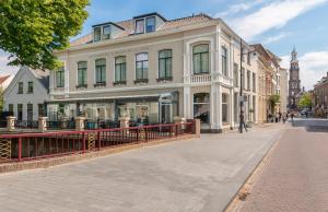 um grande edifício branco em uma rua em uma cidade em Hotel Zutphen em Zutphen