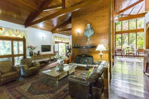 sala de estar con sofá de cuero y chimenea en Hotel Colinas de Petropolis en Petrópolis