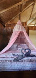 Una cama con una red encima. en Monkey Business Tours and Accommodation en Bukit Lawang