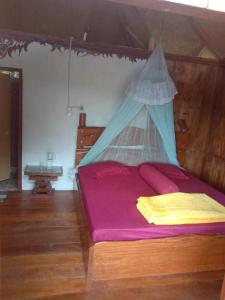 1 dormitorio con 1 cama con mosquitera en Monkey Business Tours and Accommodation en Bukit Lawang