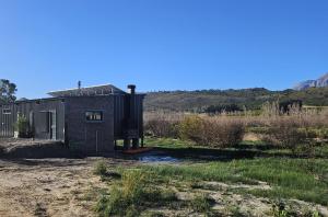 a tiny house in the middle of a field at River Edge in Romansrivier