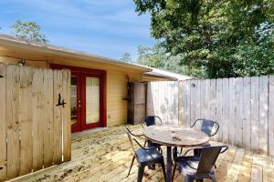 un patio con mesa, sillas y una valla en Casa Mar en Tallahassee