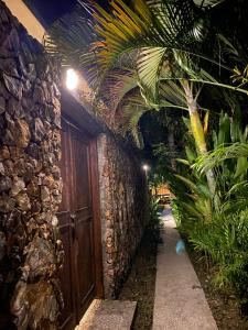 un edificio con una porta in legno e alcune piante di Palm Green Hotel a Kuta Lombok