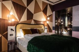 una camera con un letto con una parete geometrica di The Hide Flims Hotel a Flims