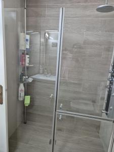 a shower with a glass door in a bathroom at La Torre, vistas a la bahía in Laredo