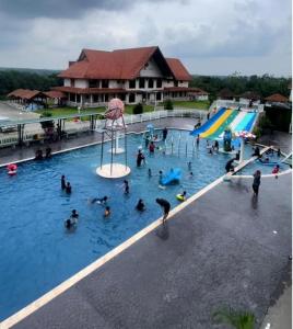 um grupo de pessoas em uma piscina em um parque aquático em Savanna Hill Resort em Johor Bahru