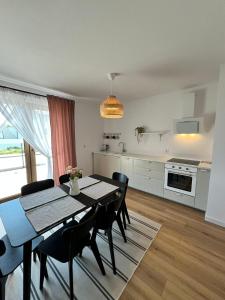 een keuken en eetkamer met een tafel en stoelen bij Domek całoroczny Marta Jeka in Władysławowo