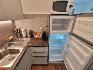 a kitchen with an open refrigerator with a microwave at Confortevole appartamento nel cuore di Lugano in Lugano