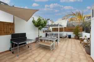 een patio met tafels en stoelen op een balkon bij Kite & Surf Nomad House in Las Palmas de Gran Canaria