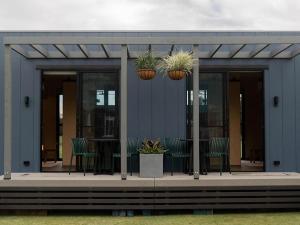 un edificio con mesa, sillas y plantas en Ingenia Holidays Byron Bay en Byron Bay