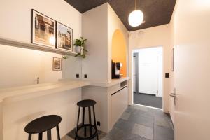 una cucina con due sgabelli e un bancone con bar di Fred Guest House Zürich Hauptbahnhof a Zurigo