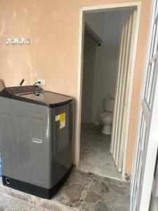 ein Badezimmer mit einem Mülleimer neben einem WC in der Unterkunft Casa frente al centro comercial in Montería