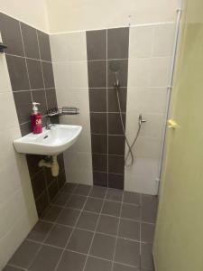 a bathroom with a sink and a shower with a shower at Homestay Rumoh Mok in Jitra