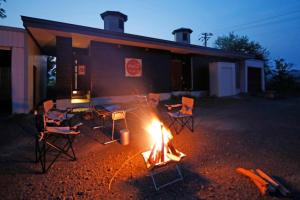 eine Gruppe von Stühlen um ein Feuer vor einem Gebäude in der Unterkunft Starry Sky Cottage 15 in Kitami