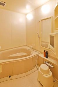 ein Bad mit einer Badewanne und einem WC. in der Unterkunft Starry Sky Cottage 15 in Kitami