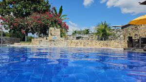 uma piscina com água azul num resort em Hotel Campestre Los Mangos em Quimbaya