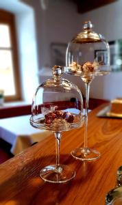 dos copas de vino sentadas sobre una mesa de madera en Glacier Rock guesthouse en Solda