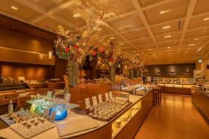 un restaurante con mesas largas, sillas y flores en Washu Blue Resort風籠 Kasago, en Kurashiki