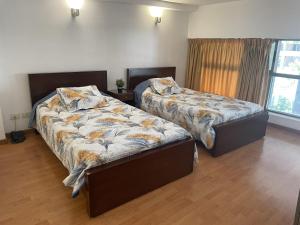 1 dormitorio con 2 camas y ventana en Duplex Siwar in a Deluxe Complex pool A-20 en Adūnīs