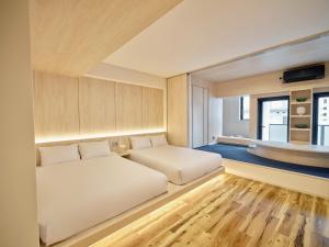 um quarto com 2 camas e uma janela em UH Suite Namba Station em Osaka