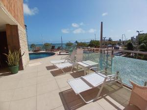 um grupo de cadeiras sentadas ao lado de uma piscina em Iracema Residence by Escala Imóveis em Fortaleza