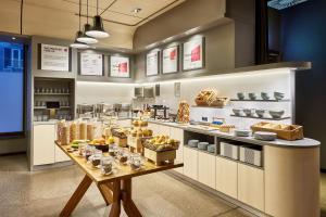 a bakery with a table with food on it at Aloft München in Munich