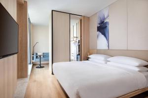 1 dormitorio con 1 cama blanca grande y TV en Fairfield by Marriott Beijing Haidian en Beijing