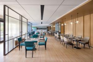 un comedor con mesas, sillas y ventanas en Fairfield by Marriott Beijing Haidian en Beijing