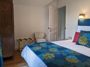 een slaapkamer met een groot bed en een blauwe deken bij Villa Eliane - parking privé in Étretat