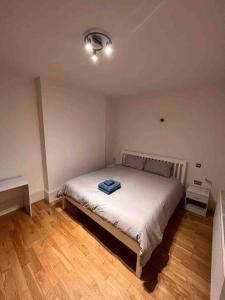 Un dormitorio con una cama con una toalla azul. en 2 bed garden flat West Dulwich FREE STREET PARKING en Londres