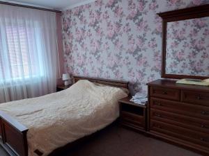 a bedroom with a bed and a dresser and a mirror at 2-х комнатная квартира in Korostenʼ