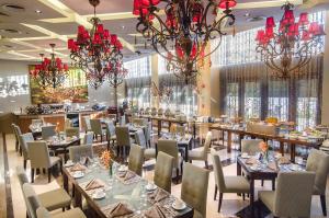 une salle à manger avec des tables, des chaises et des lustres dans l'établissement The Avenue Plaza Hotel, à Naga