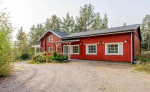 een rood huis met een onverharde weg ervoor bij Lomahyppäys in Naantali