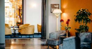 a lobby with two chairs and a table with flowers at Grand Hotel Karel V in Utrecht