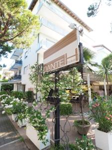 um sinal em frente a um edifício com plantas em Hotel Dante em Lido di Jesolo