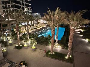 widok na ośrodek z palmami i basenem w obiekcie Address Beach Resort Residence Bahrain w mieście Manama