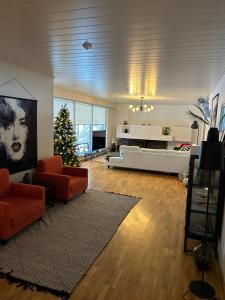 ein Wohnzimmer mit Sofas und einem Weihnachtsbaum in der Unterkunft Villa Koivu 100m2 3mh, pöytätennis, Grilli, ihana puutarha in Seinäjoki