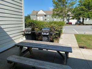 un banco de madera sentado en una acera junto a un edificio en Comfy Condo With Amazing View of Gatlinburg and the Smokies, en Gatlinburg