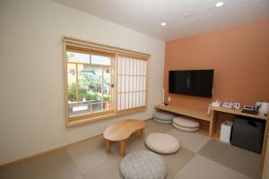 a room with a desk and a television and a chair at みつくりHOTEL in Tuyama