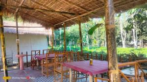 un grupo de mesas y sillas en un restaurante en Tranquil Bambusic Bliss, en Kāziranga