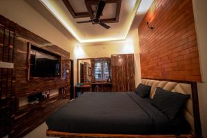 1 dormitorio con 1 cama grande y pared de ladrillo en Melody Inn Luxury Home Stay, en Yercaud