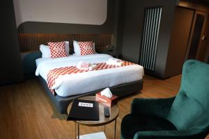 ein Hotelzimmer mit einem Bett, einem Tisch und einem Stuhl in der Unterkunft NW 4896 Theater Hotel in Ban Khlong Phruan