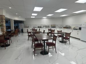 uma sala de jantar com mesas e cadeiras e uma cozinha em River Rapids Inn em Cataratas do Niágara