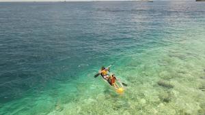 une personne rame un kayak dans l'eau dans l'établissement iHaven Thulusdhoo, à Thulusdhoo