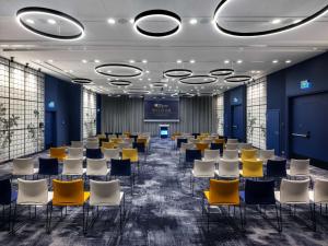 a conference room with chairs and a stage in the middle at Hilton Garden Inn Krakow Airport in Kraków